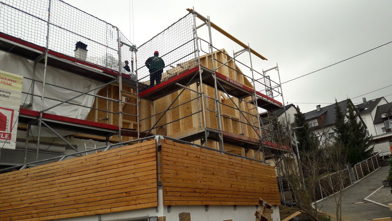 Dachaufstockung mit Holzfassade im Gerüst